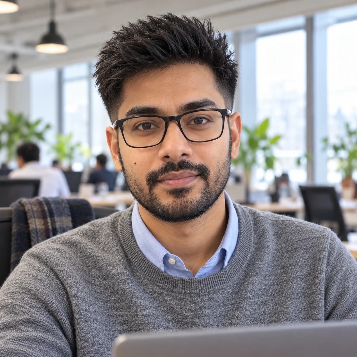Man in his early 30s with two and a half inches of straight hair brushed straight up over a low fade, front view in a coworking space