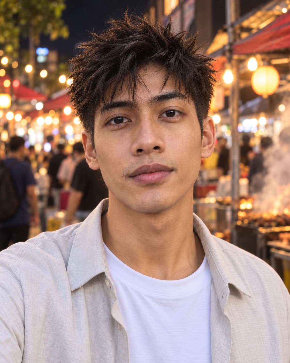 Young man with thick straight hair cut two inches on top into choppy separated spikes over a #2 taper, front view at a night market